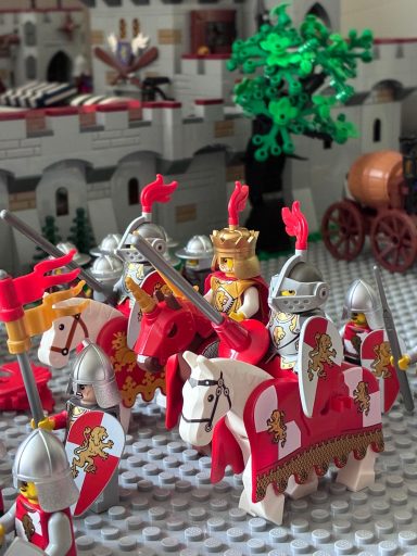 Een groep LEGO-ridders en een koning te paard in een middeleeuwse setting.