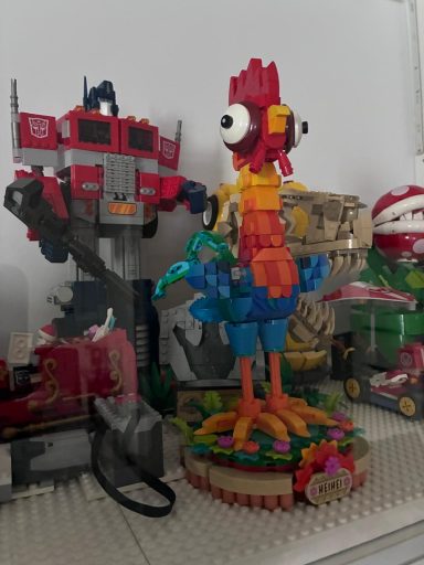 Een kleurrijke vogel van bouwsteentjes naast een robotfiguur.