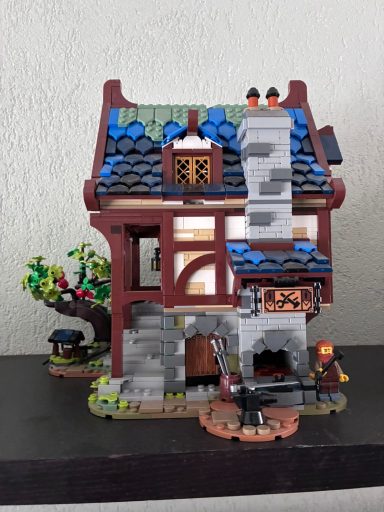 Kleurige LEGO-huis met een groene dak, stenen schoorsteen en een tuinboom.